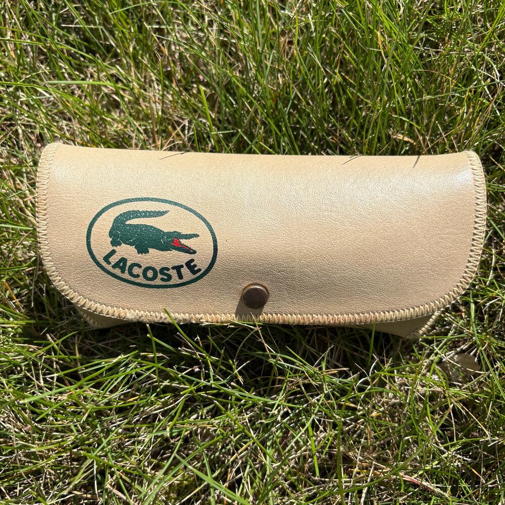 Beige Lacoste snap-close sunglasses case with classic green crocodile logo